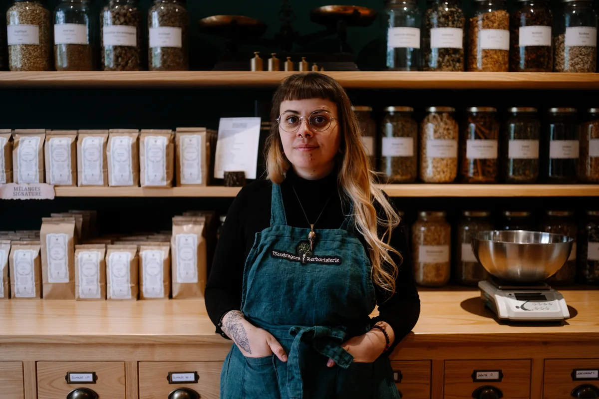 Juliette Walek dans son herboristerie, devant les bocaux de plantes médicinales